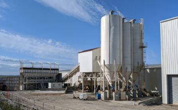 A concrete production plant , with 3 silos and a conveyor belt