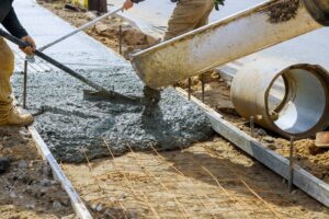 Cement truck mixer pouring fresh concrete on reinforcements.