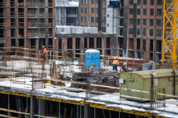 construction of modern high-rise buildings in wintertime. aerial view from flying drone.